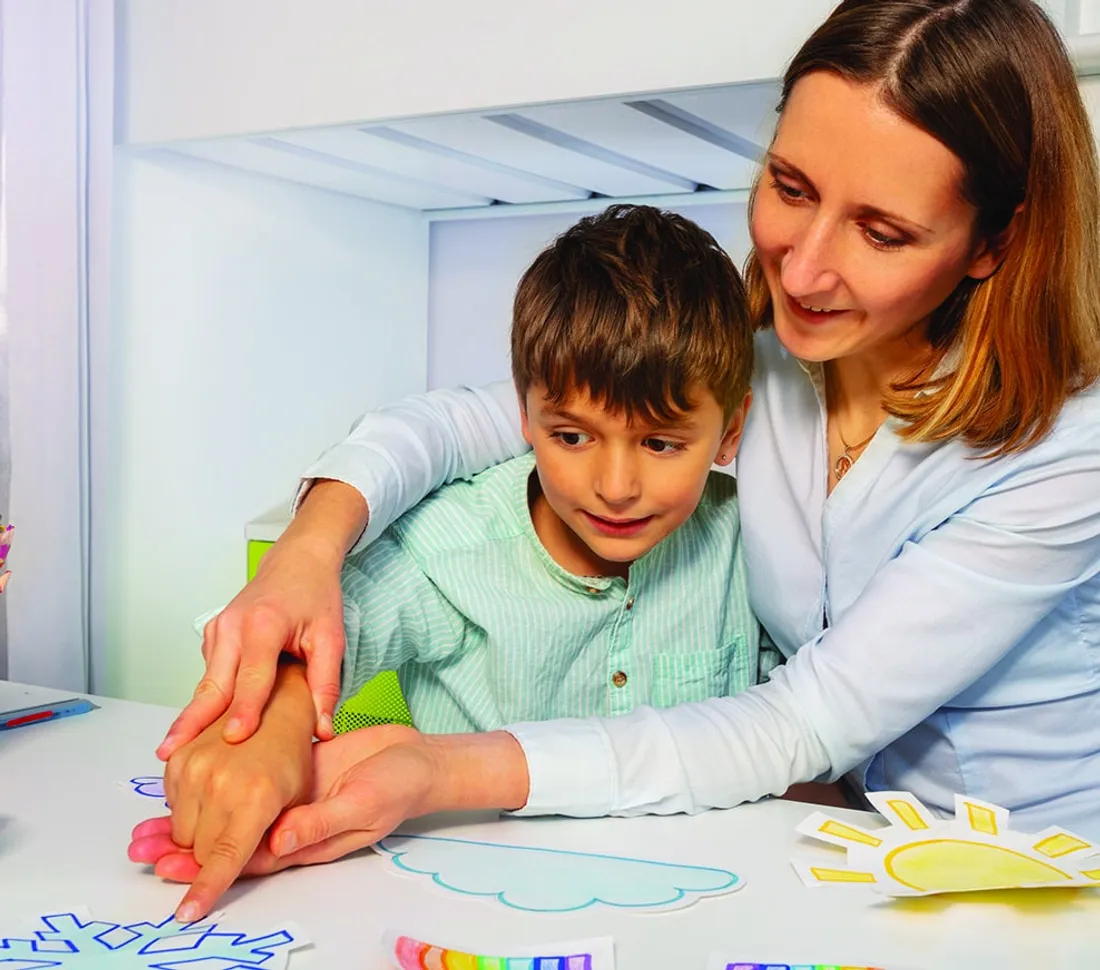 Caregiver working with a child on learning activities